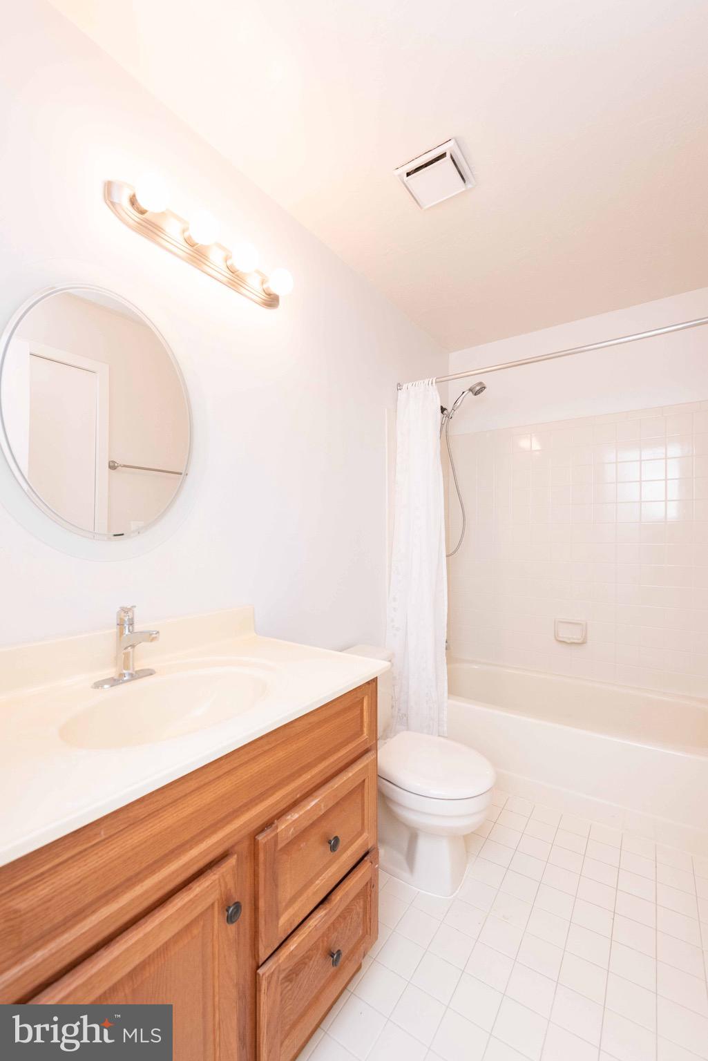 11708 Summerchase Circle, Unit 1708E Reston, VA 20194 - Photo 16 of 17 a bathroom with a granite countertop sink a toilet and a mirror