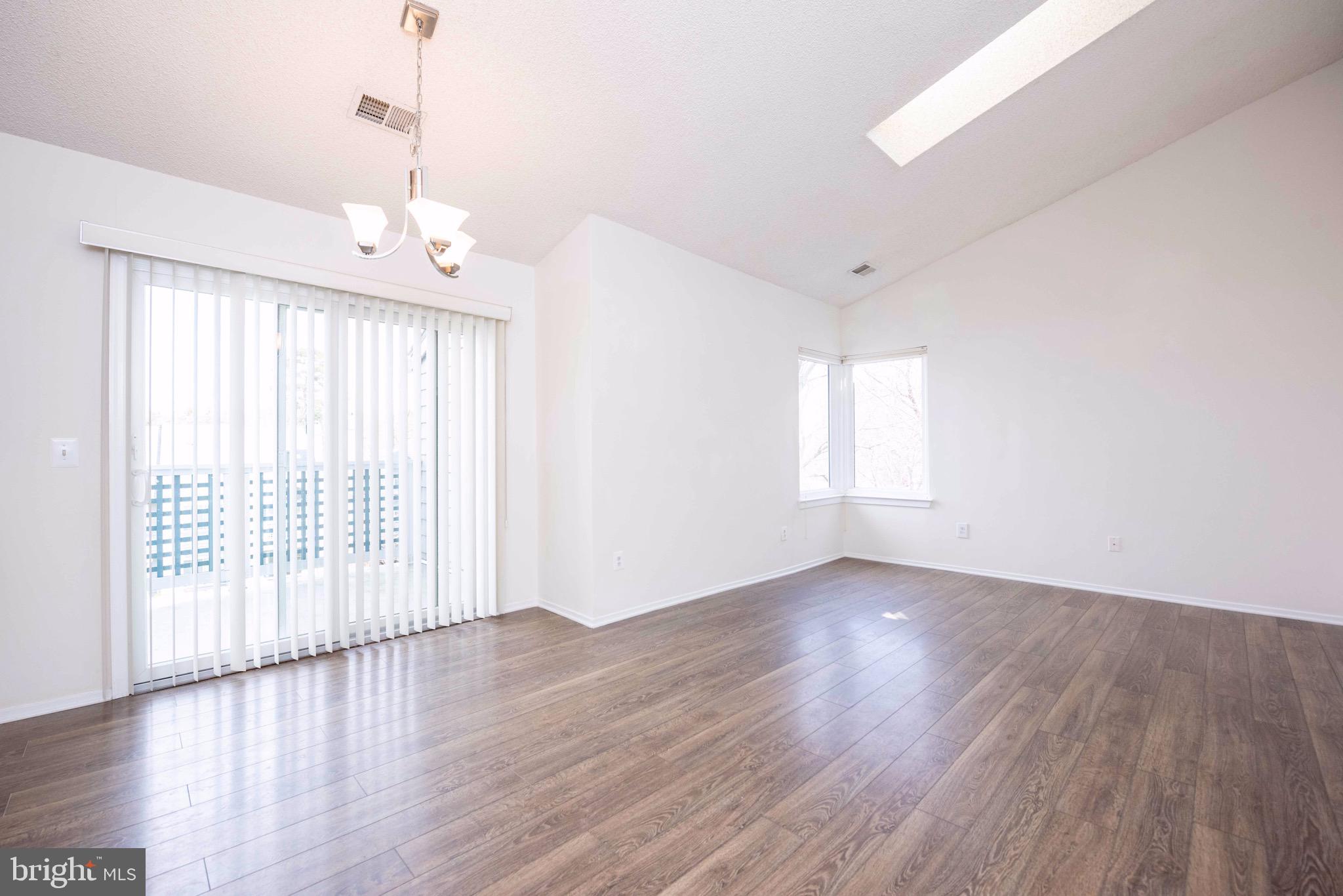 11708 Summerchase Circle, Unit 1708E Reston, VA 20194 - Photo 4 of 17 a view of an empty room with wooden floor and a window