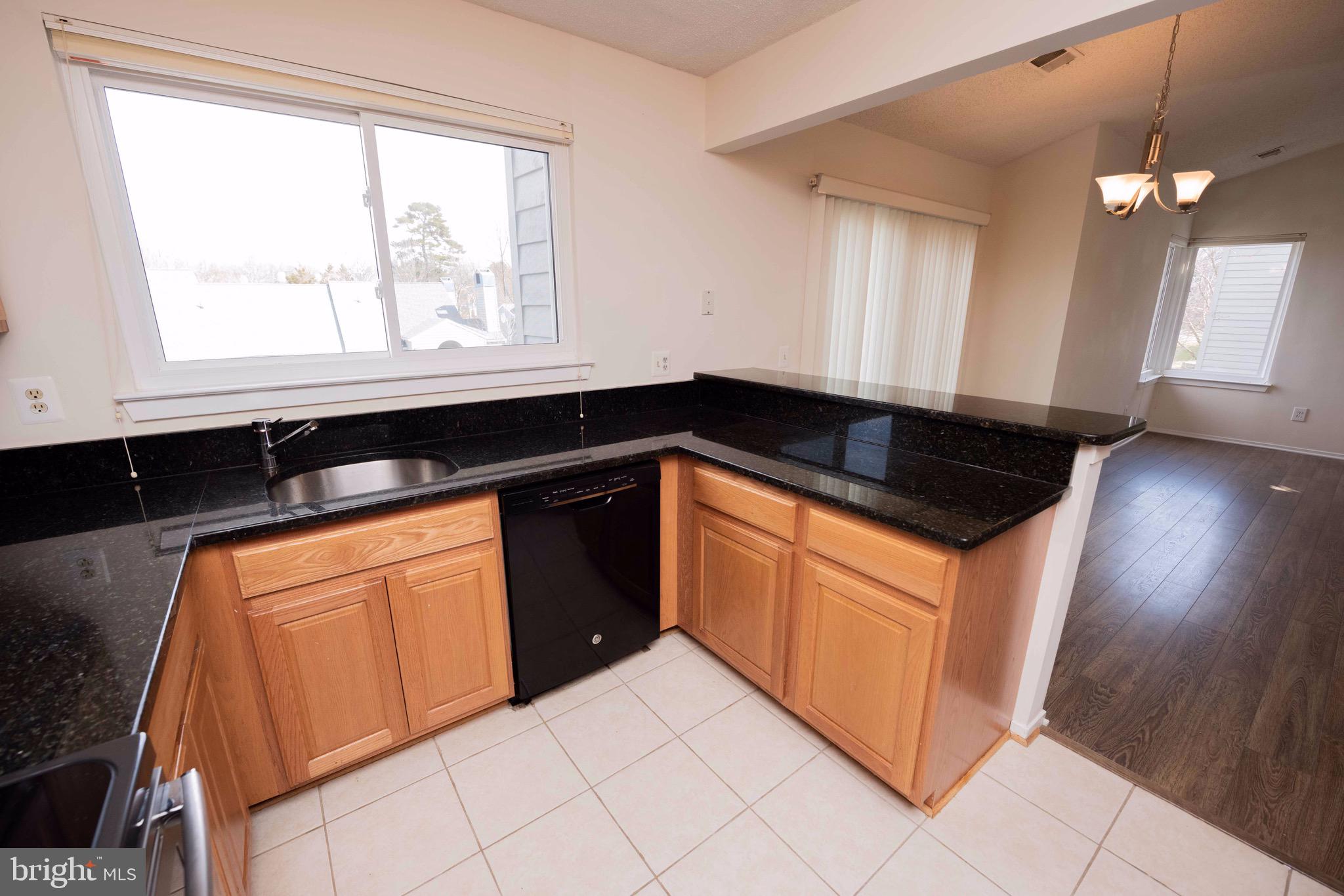 11708 Summerchase Circle, Unit 1708E Reston, VA 20194 - Photo 5 of 17 a kitchen with granite countertop white cabinets and a granite counter top