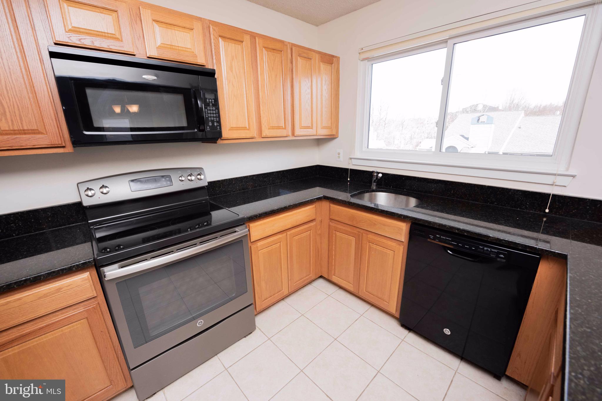 11708 Summerchase Circle, Unit 1708E Reston, VA 20194 - Photo 6 of 17 a kitchen with stainless steel appliances granite countertop cabinets and a stove top oven