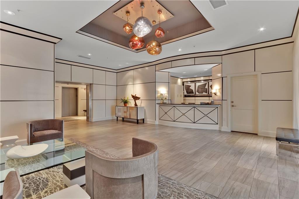 2828 Peachtree Road Northwest, Unit 1402 Atlanta, GA 30305 - Photo 12 of 23 a living room with couches and kitchen view with wooden floor