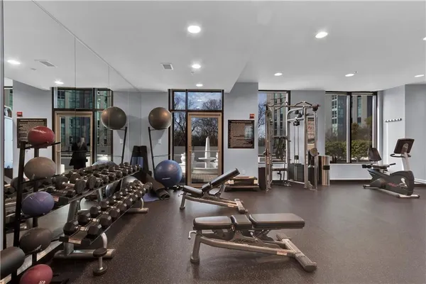 a room with gym equipment and large windows