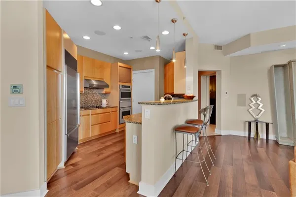 a open kitchen with white cabinets and stainless steel appliances
