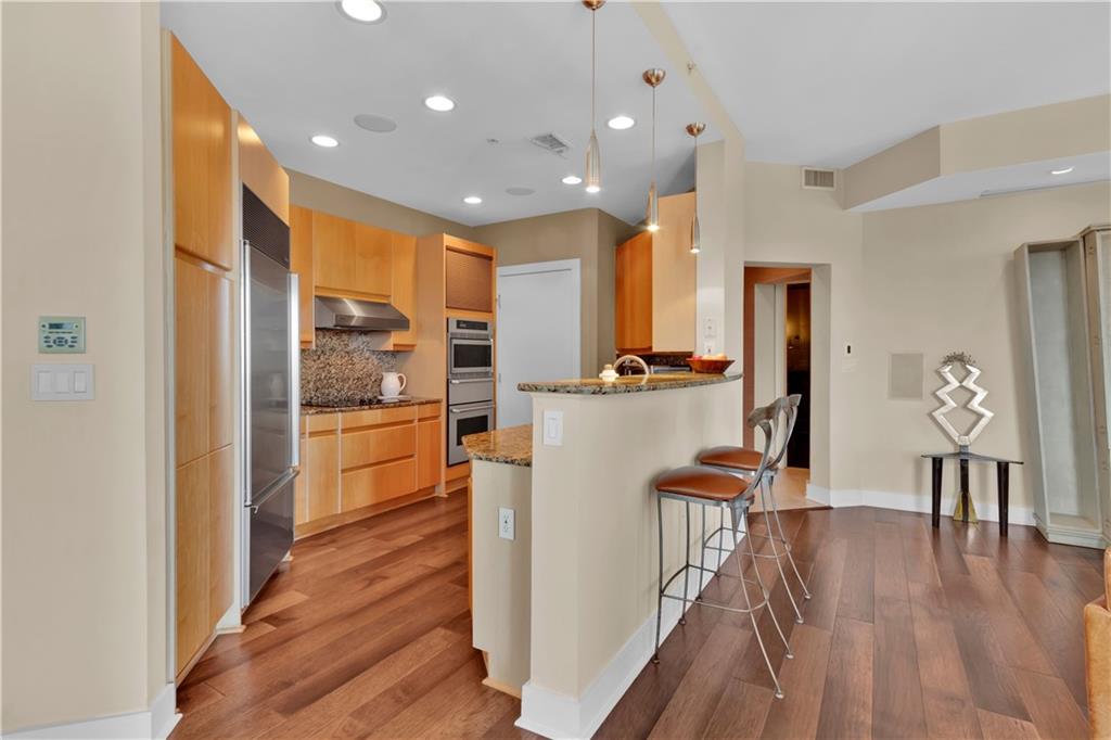 2828 Peachtree Road Northwest, Unit 1402 Atlanta, GA 30305 - Photo 15 of 23 a open kitchen with white cabinets and stainless steel appliances