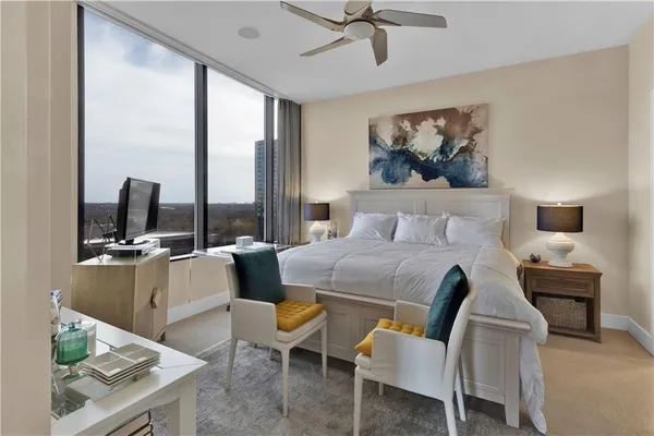 a bedroom with a bed a large window and table