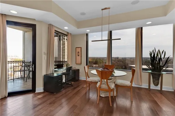 a living room with furniture a large window and wooden floor
