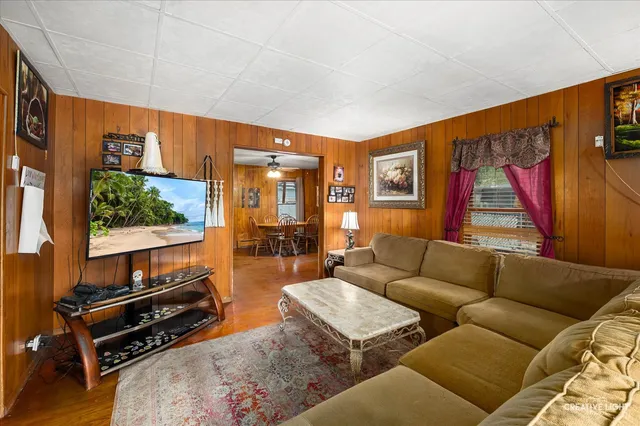 a living room with furniture a flat screen tv and a window