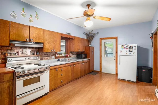 a kitchen with stainless steel appliances a stove cabinets and wooden floor