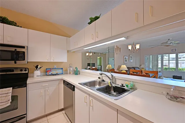 a kitchen with sink a microwave and cabinets