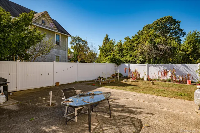 a backyard of a house with table and chairs