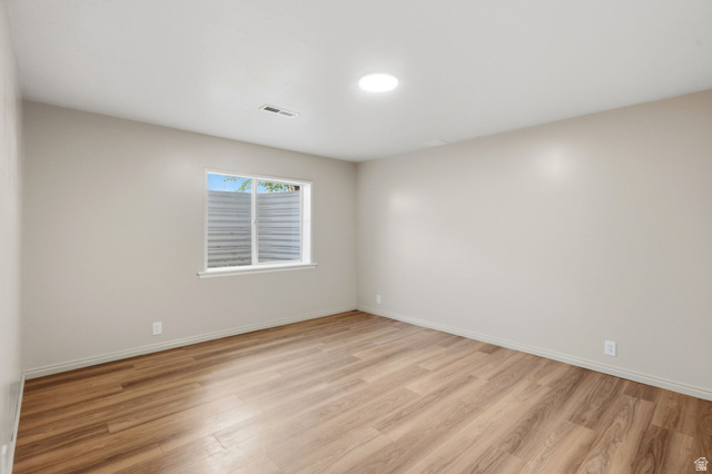 3732 Campbell Road Tooele, UT 84074 - Photo 20 of 69 Spacious room featuring wood-finish flooring, a window with exterior grating, a recessed ceiling light, and light-toned wall finishes