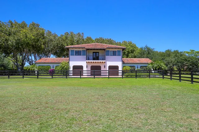 a front view of a house with a yard and fountain