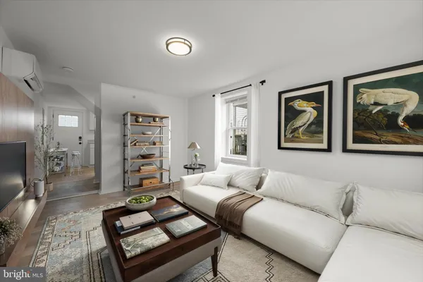 a living room with furniture and a painting on the wall