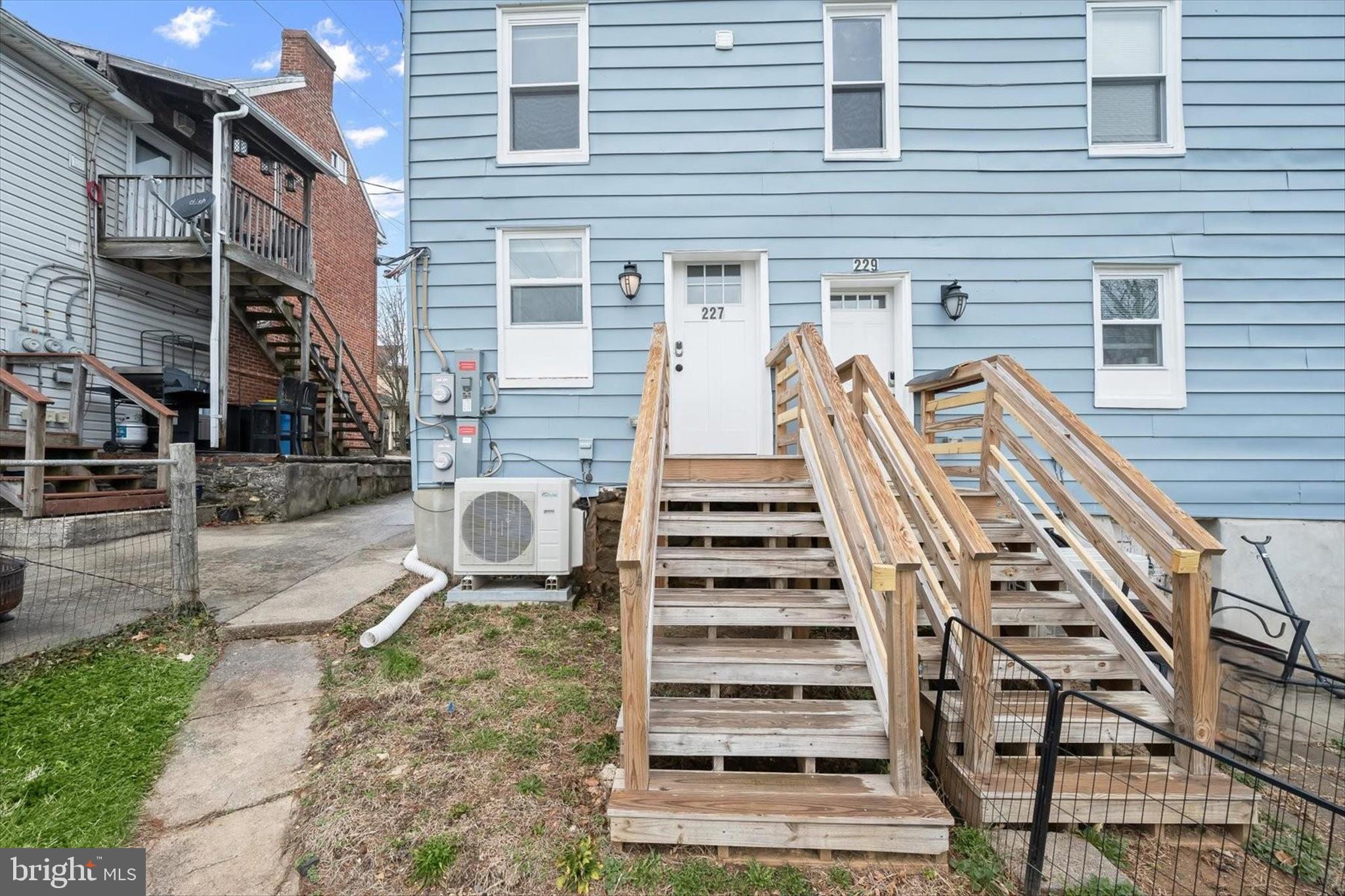 227-229 Main Street New Windsor, MD 21776 - Photo 27 of 36 a view of a patio with two couches and deck with wooden floor and fence