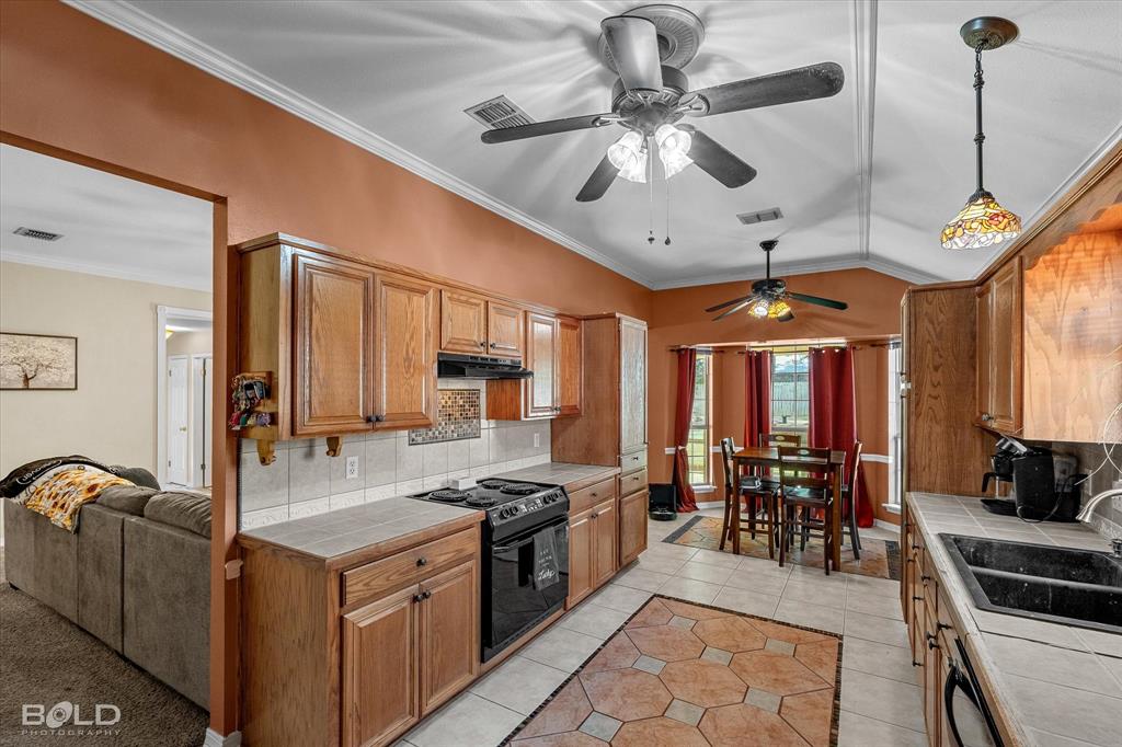 122 Ragan Lane Haughton, LA 71037 - Photo 12 of 34 Kitchen featuring wood cabinetry, tile countertops, and a full suite of appliances