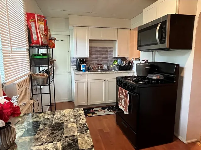a kitchen with stainless steel appliances granite countertop a stove a sink and a microwave