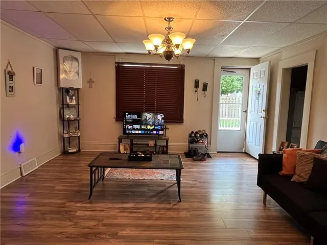 a living room with furniture a window and a chandelier