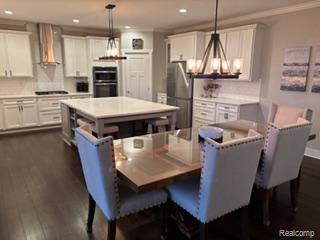 2500 Walnut View Drive Howell, MI 48855 - Photo 16 of 41 Dining space featuring a chandelier, dark wood-style floors, and recessed lighting