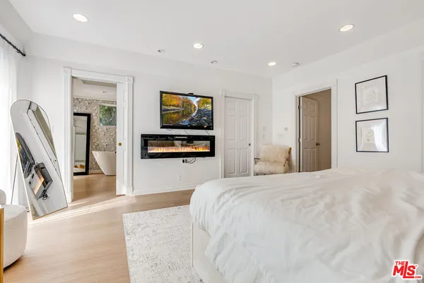 a bedroom with furniture and a flat screen tv