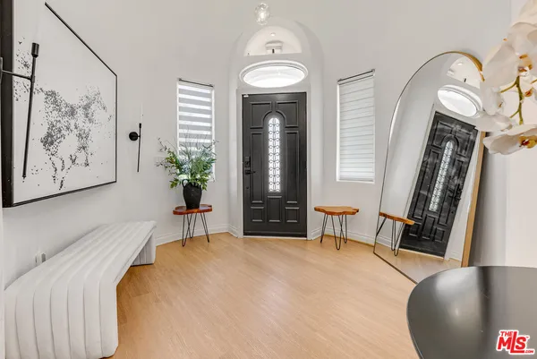 a bedroom with a large bed and a potted plant