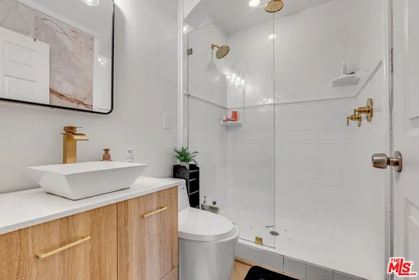 a bathroom with a sink a toilet and shower