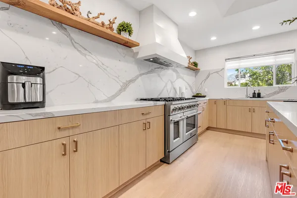 a kitchen with stainless steel appliances white cabinets and wooden floor