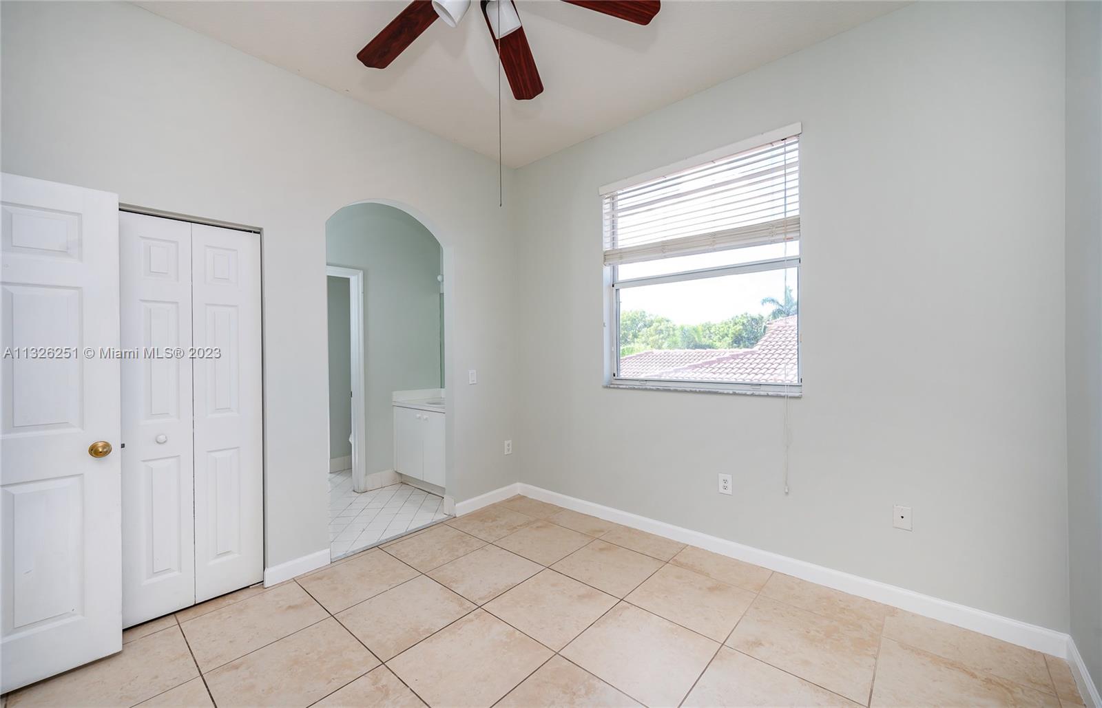 2106 Northeast 40th Road Homestead, FL 33033 - Photo 18 of 33 a view of an empty room with window and chandelier fan