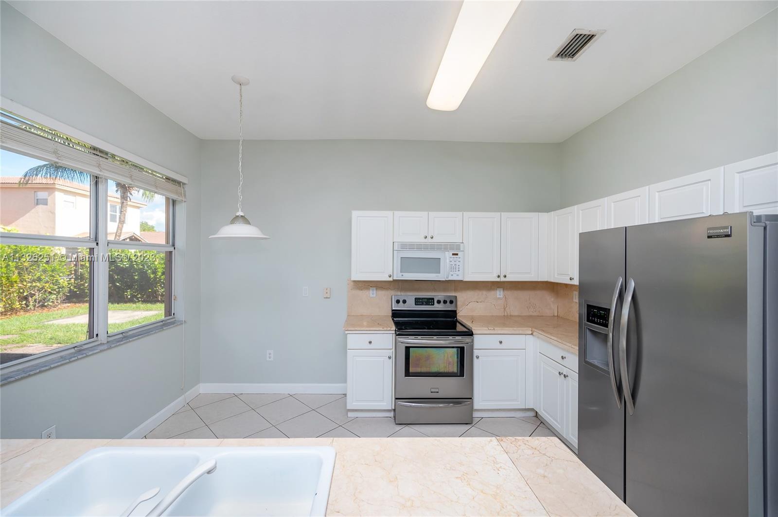 2106 Northeast 40th Road Homestead, FL 33033 - Photo 7 of 33 a kitchen with stainless steel appliances a refrigerator sink and stove