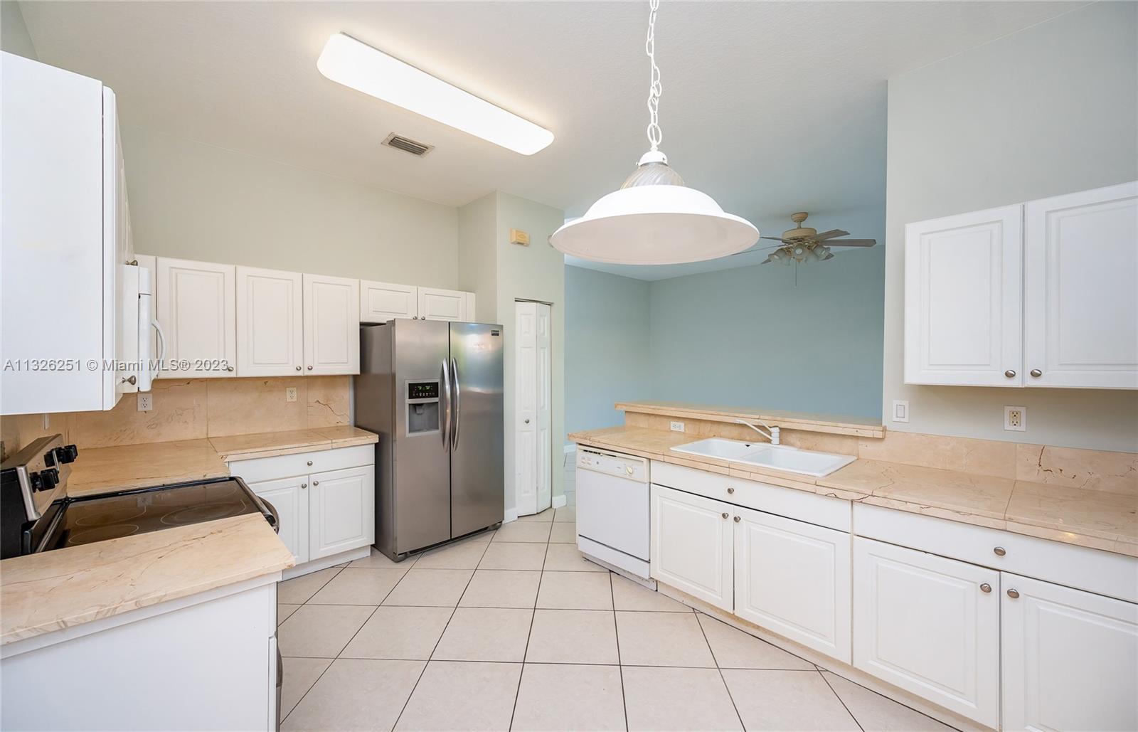 2106 Northeast 40th Road Homestead, FL 33033 - Photo 8 of 33 a kitchen with a sink cabinets and stainless steel appliances