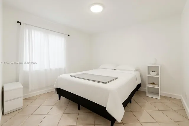 a bedroom with a bed and a lamp