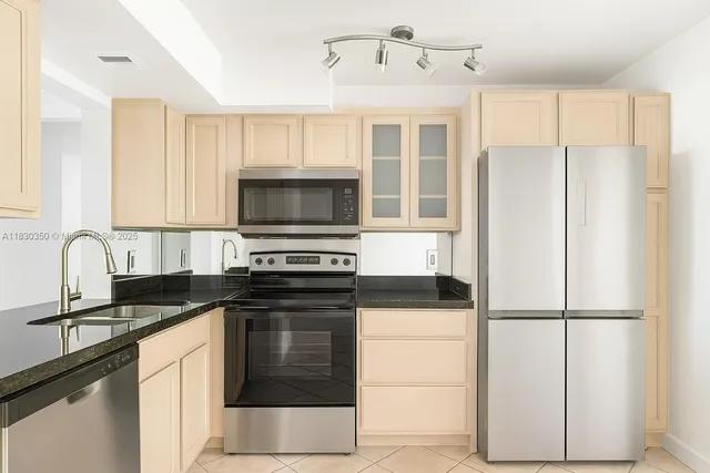 a kitchen with granite countertop a refrigerator stove and microwave