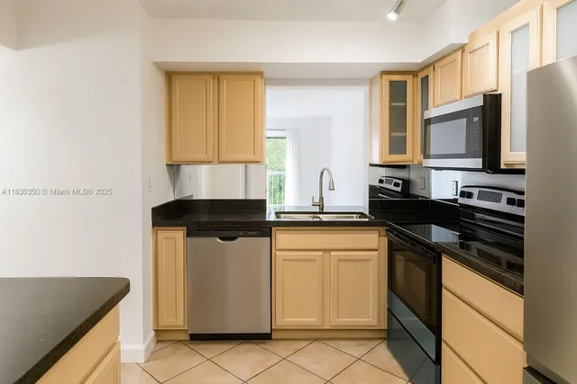 a kitchen with stainless steel appliances granite countertop a stove a sink and a microwave