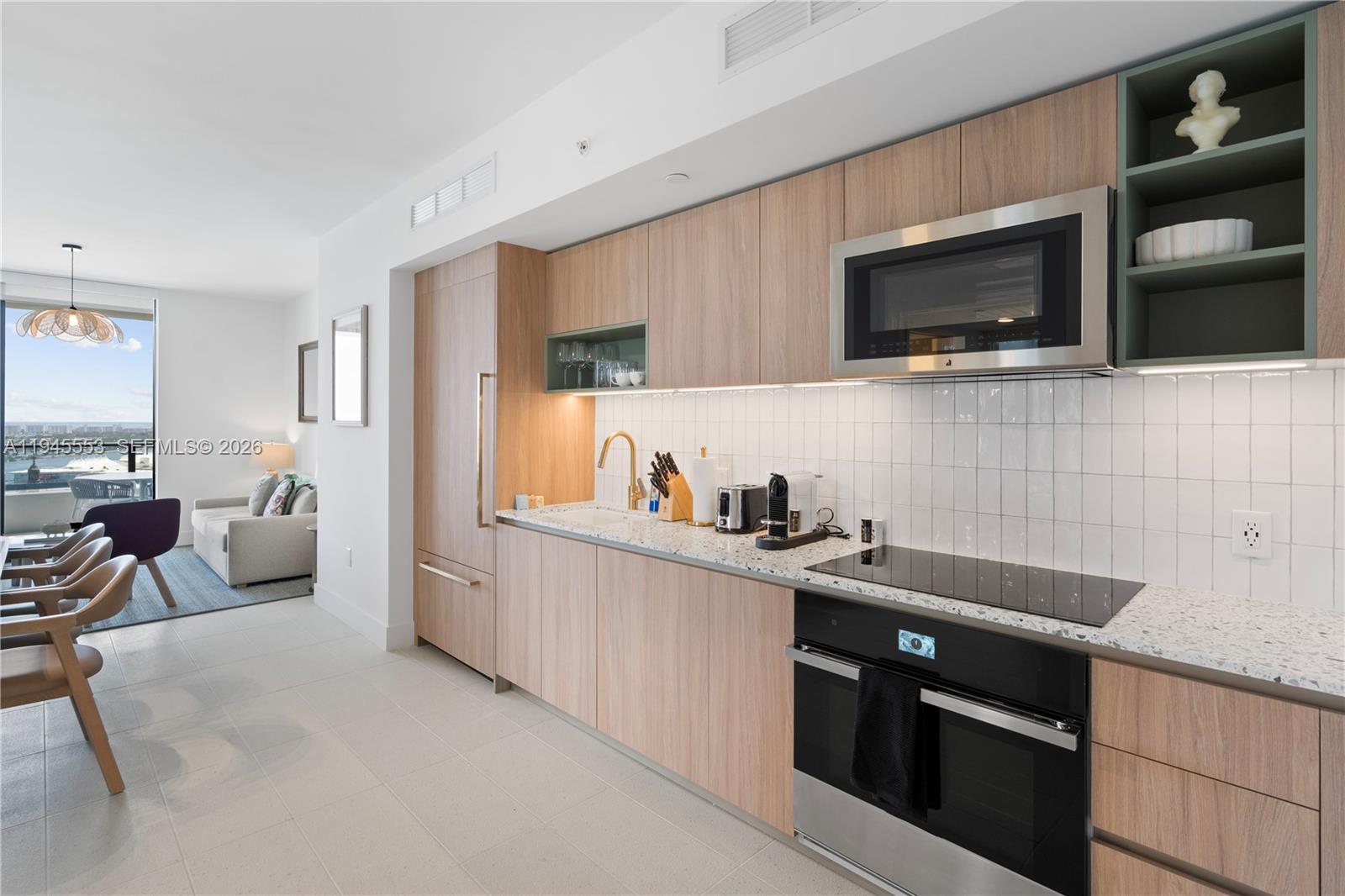 159 Northeast 6th Street, Unit 2415 Miami, FL 33132 - Photo 38 of 42 a kitchen with stainless steel appliances a stove microwave and cabinets