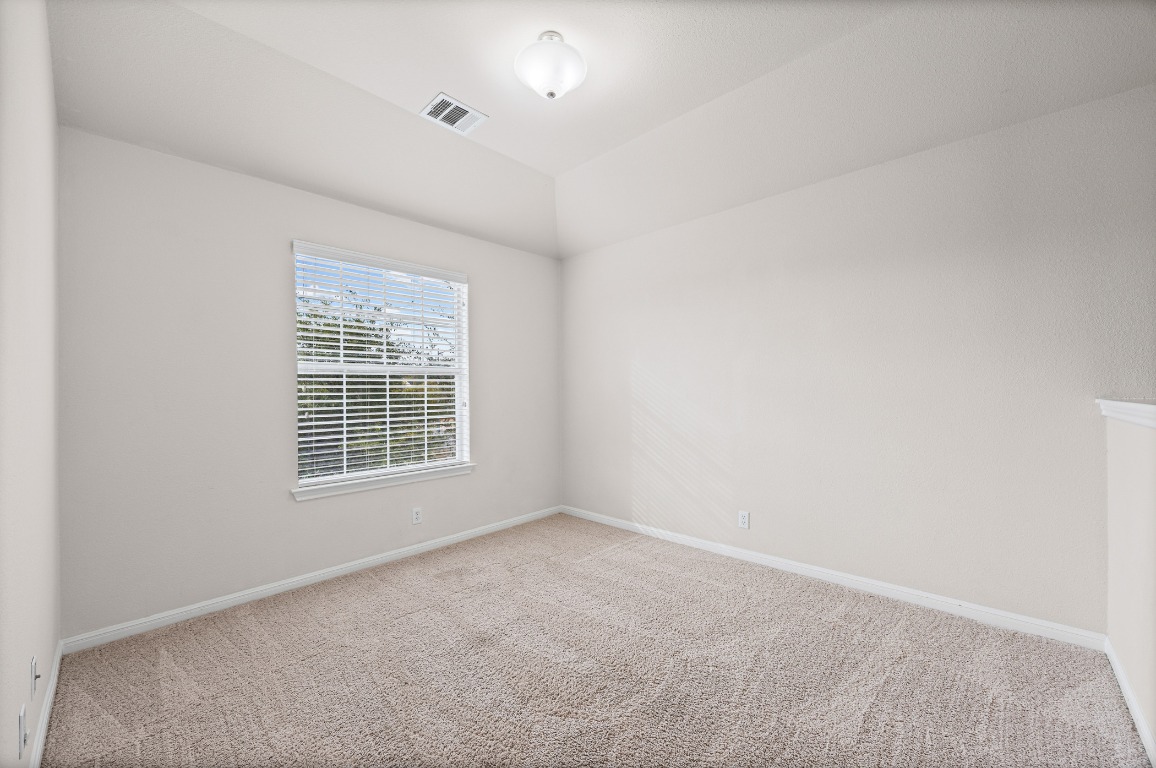 336 Celery Loop Austin, TX 78748 - Photo 11 of 32 Spare room with carpet and lofted ceiling