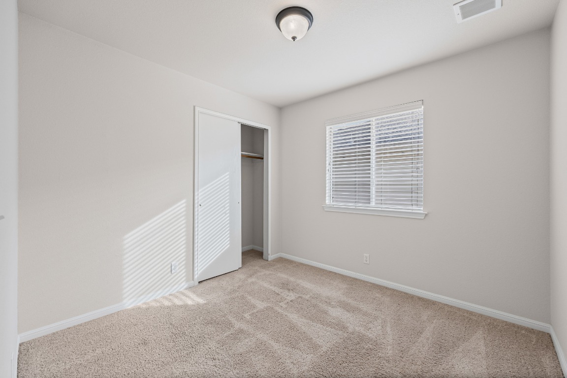 336 Celery Loop Austin, TX 78748 - Photo 15 of 32 Unfurnished bedroom featuring carpet floors and a closet