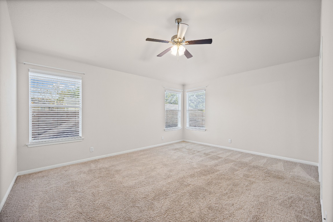 336 Celery Loop Austin, TX 78748 - Photo 16 of 32 Empty room with light carpet, healthy amount of natural light, and ceiling fan