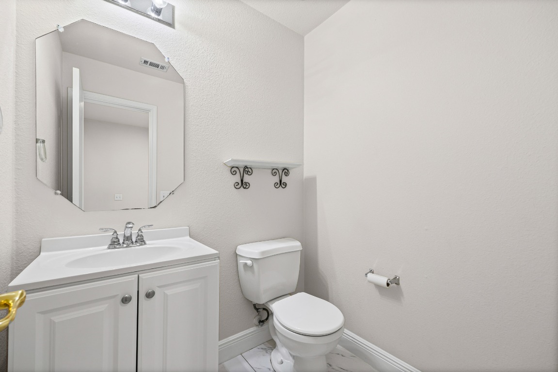 336 Celery Loop Austin, TX 78748 - Photo 20 of 32 Half bathroom featuring vanity, light marble finish flooring, and a textured wall