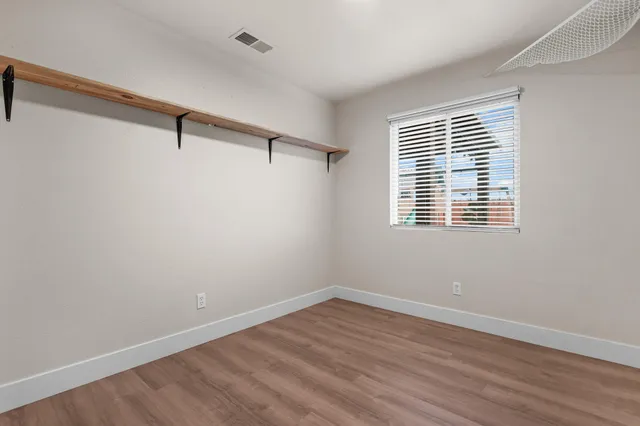 a view of a room with wooden floor and windows