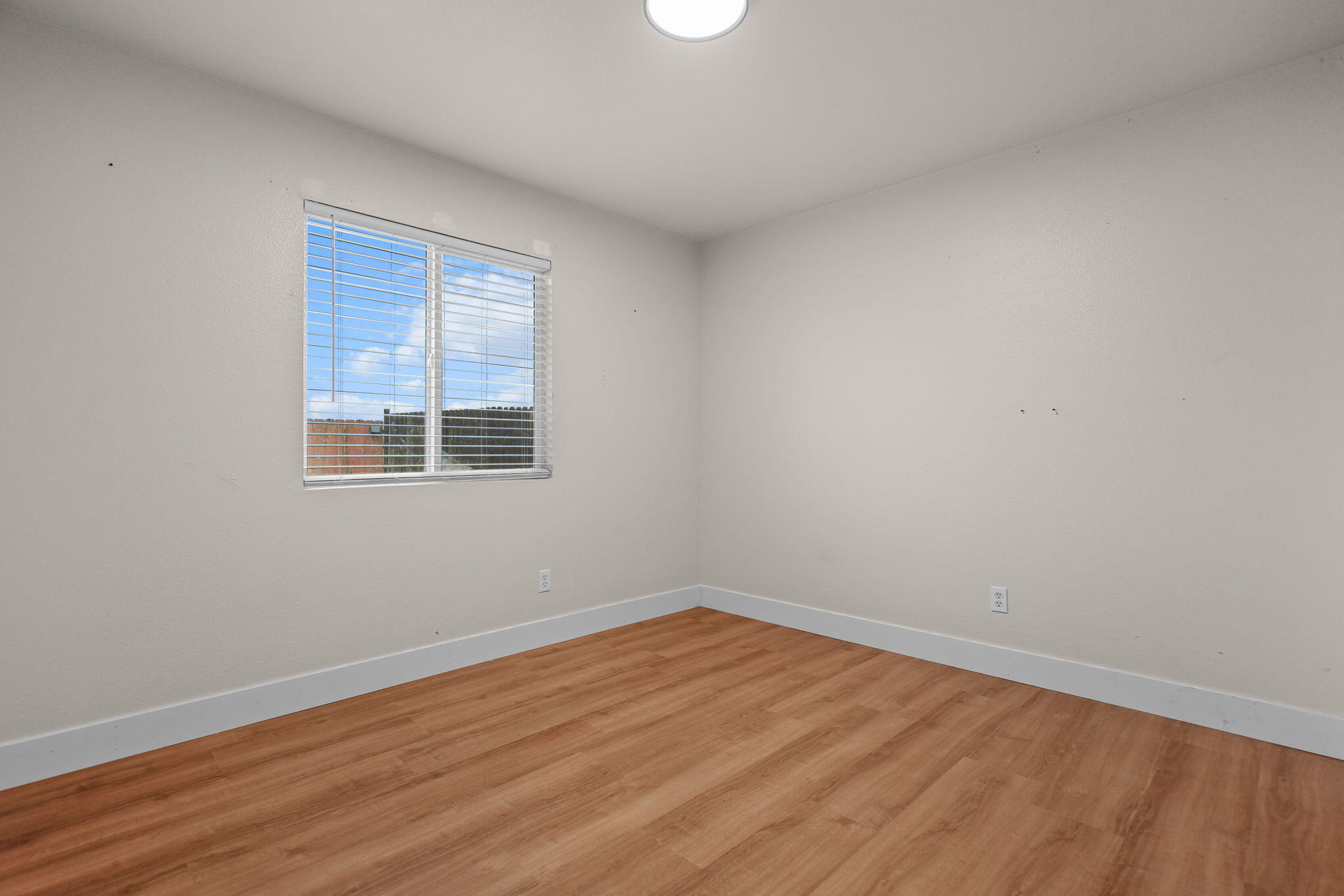 2132 Reta Way Red Bluff, CA 96080 - Photo 18 of 43 an empty room with wooden floor and windows