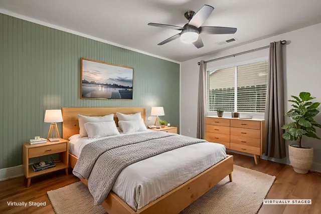 a bedroom with a large bed and a potted plant