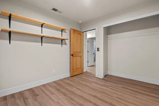 a view of empty room with wooden floor