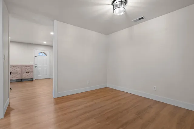 a view of empty room with wooden floor
