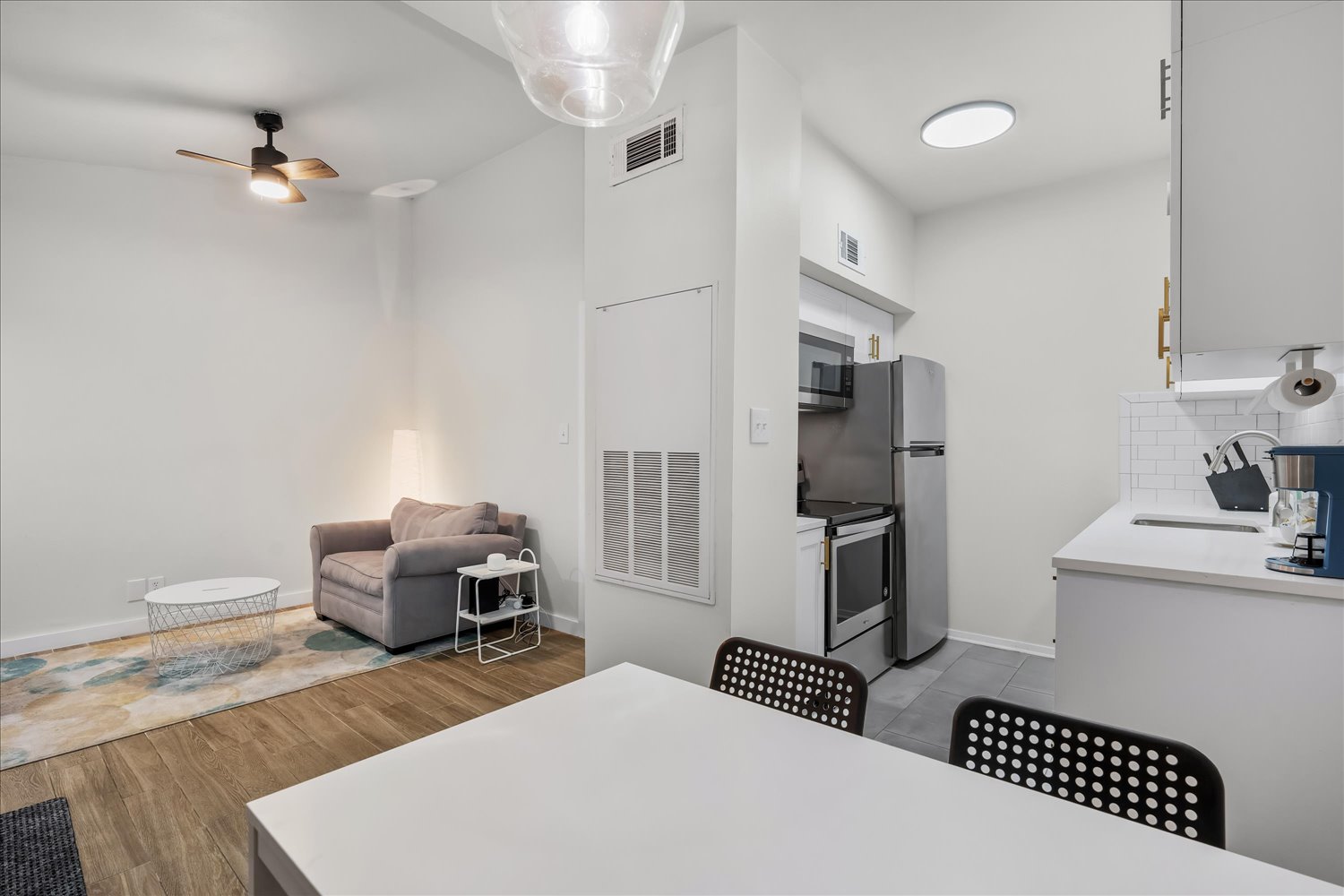 3316 Guadalupe Street, Unit 310 Austin, TX 78705 - Photo 1 of 38 Kitchen with stainless steel appliances, wood finished floors, a ceiling fan, backsplash, and light countertops