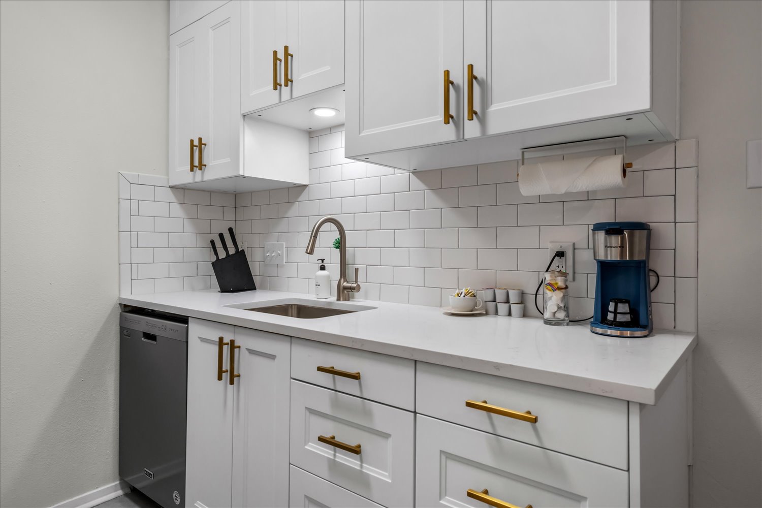 3316 Guadalupe Street, Unit 310 Austin, TX 78705 - Photo 14 of 38 Kitchen featuring stainless steel dishwasher, decorative backsplash, and white cabinetry