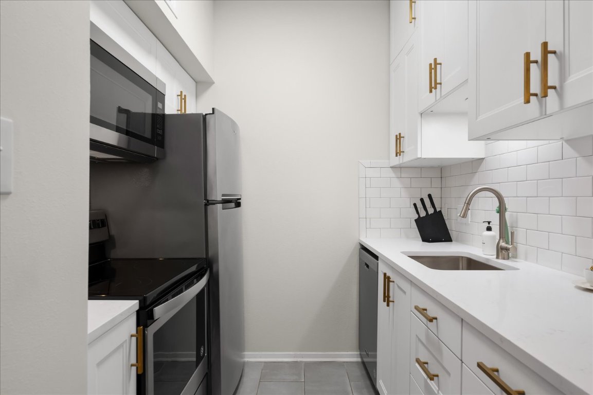 3316 Guadalupe Street, Unit 310 Austin, TX 78705 - Photo 16 of 38 a kitchen with stainless steel appliances granite countertop a sink stove and refrigerator