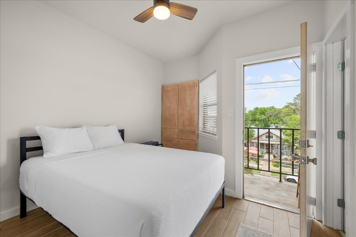 3316 Guadalupe Street, Unit 310 Austin, TX 78705 - Photo 18 of 38 a bedroom with a balcony a bed and a chandelier