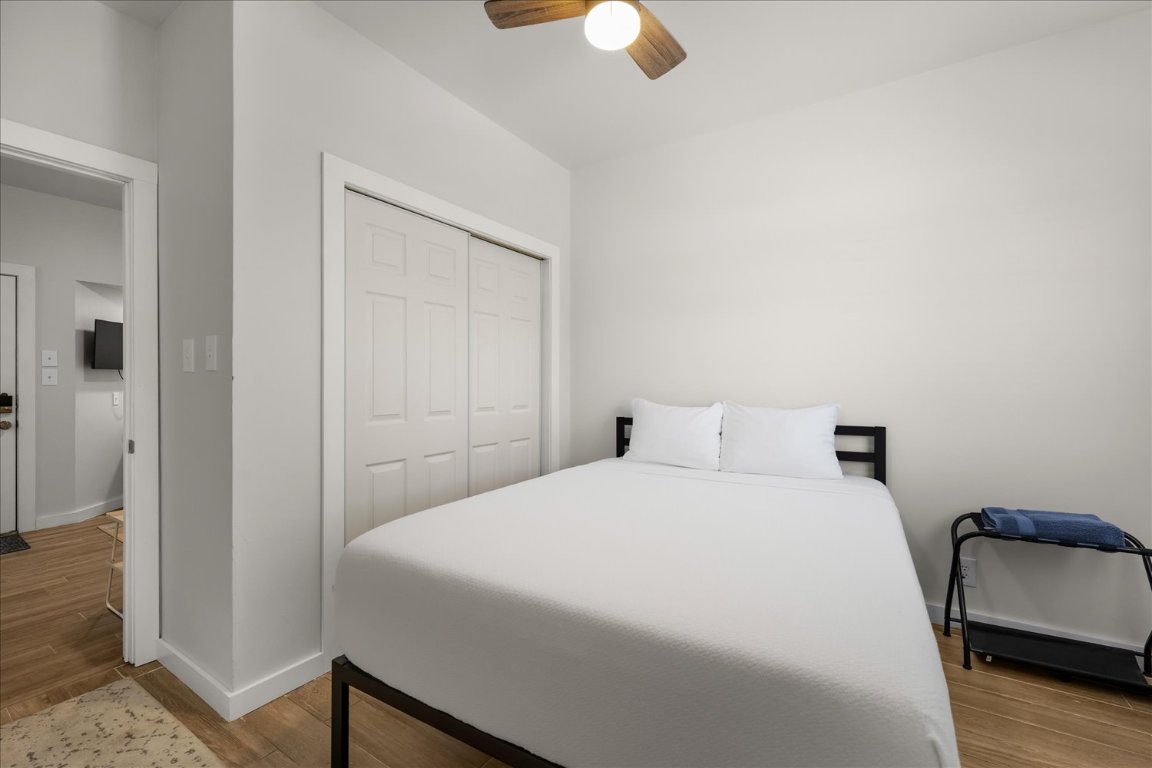 3316 Guadalupe Street, Unit 310 Austin, TX 78705 - Photo 20 of 38 a bedroom with a bed and wooden floor