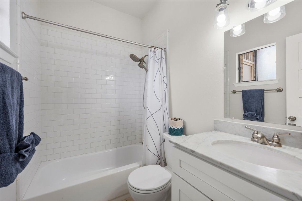 3316 Guadalupe Street, Unit 310 Austin, TX 78705 - Photo 24 of 38 a bathroom with a granite countertop bathtub shower sink vanity and toilet