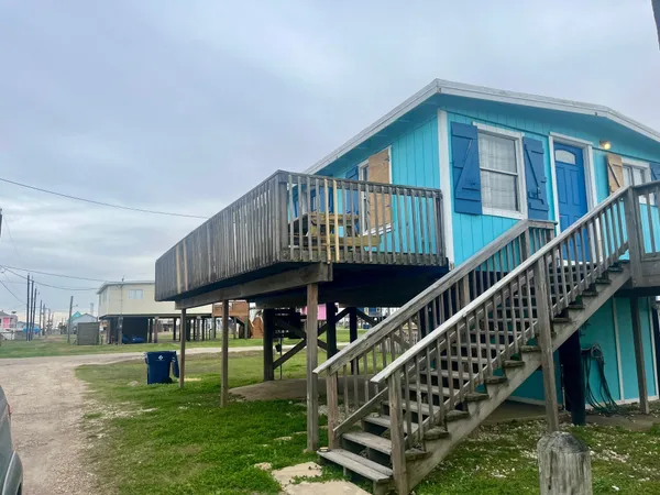 a view of an house with a deck and a yard