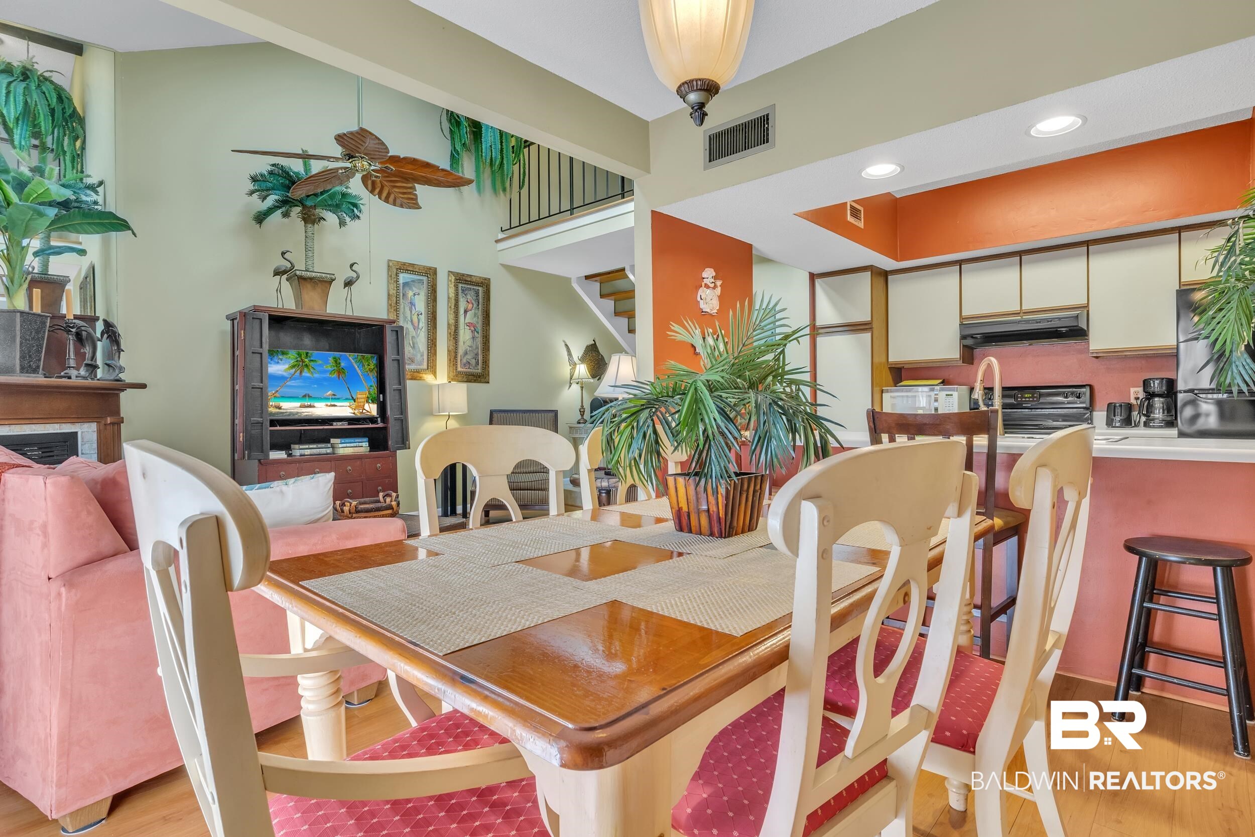 3256 Loop Road, Unit 2 Orange Beach, AL 36561 - Photo 12 of 25 Open-concept dining area featuring wood-finish flooring, a contemporary ceiling fan, and a kitchen pass-through